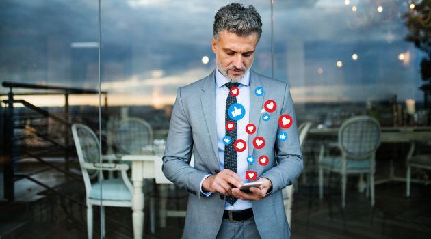 CEO standing with a phone where he is active on social media